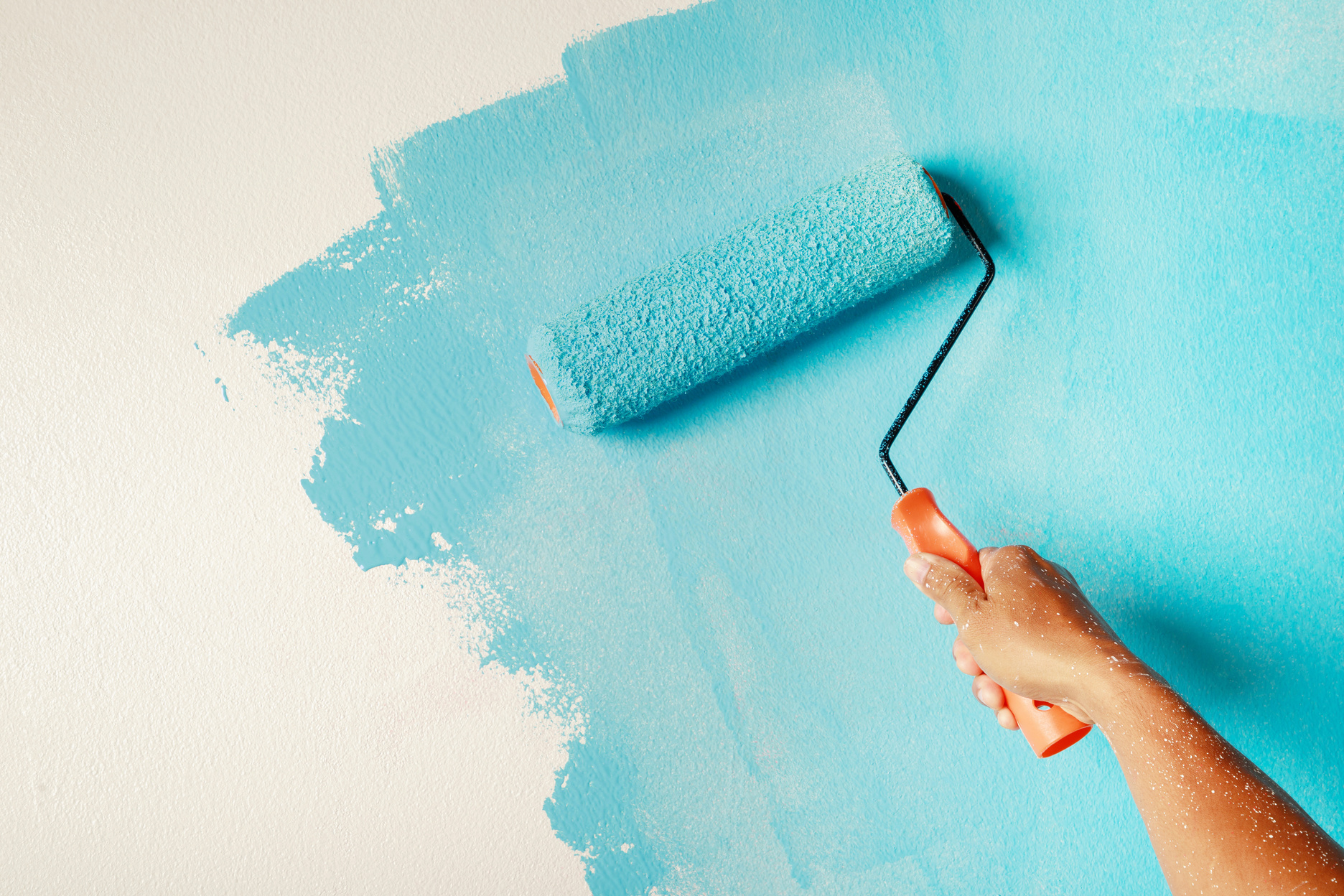 Person Painting Wall with Blue Paint